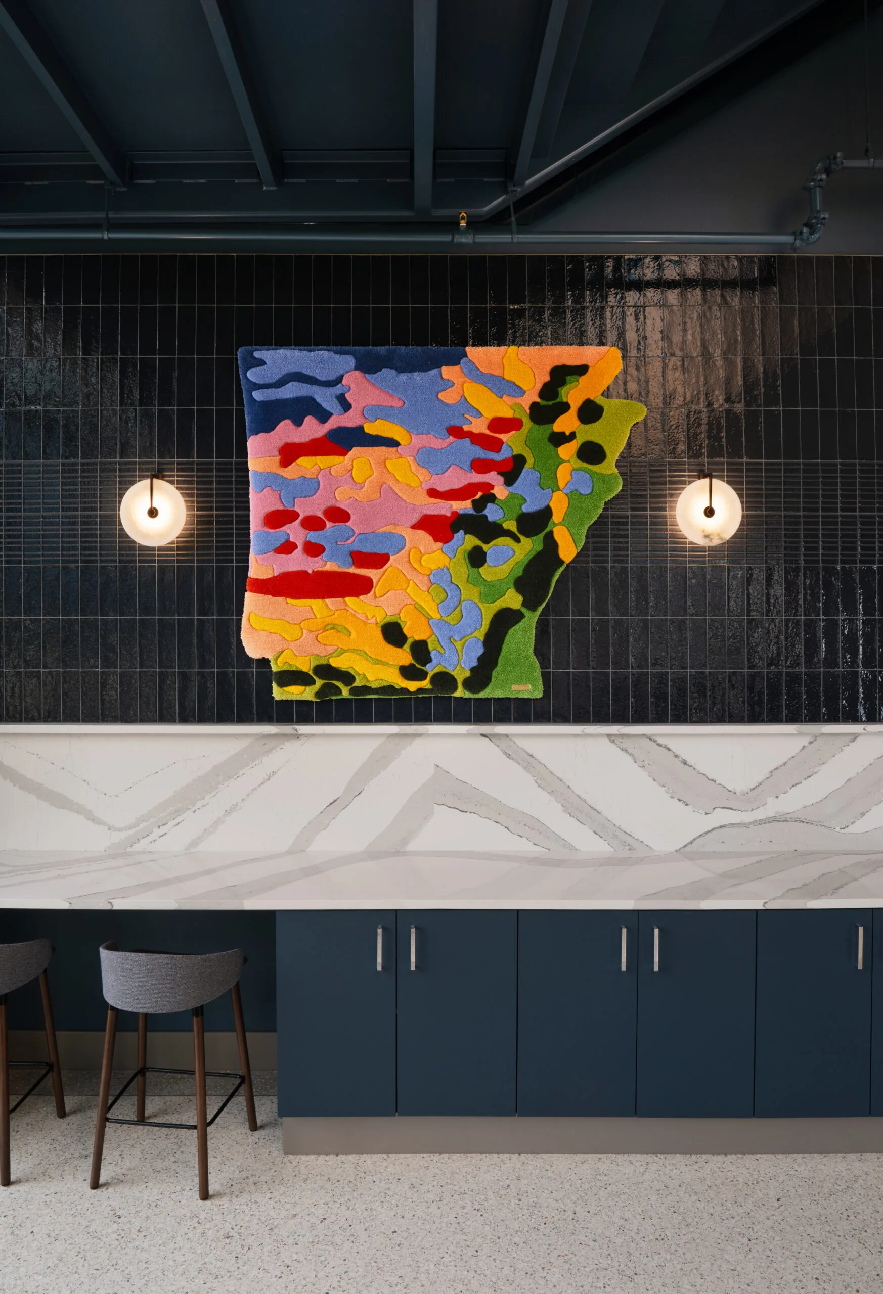 Fiber artwork in the shape of Arkansas installed above a counter at The Visionaries, curated by MIXD Gallery